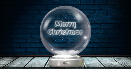 Image of christmas snow globe with christmas greetings text and snow falling on brick background. Christmas, festivity, tradition and celebration concept digitally generated image.の写真素材