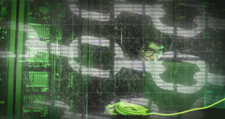 Image of data processing over asian male hacker in server room. global technology and digital...