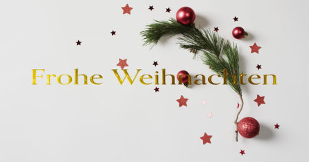 Image of frohe weihnachten text over christmas decorations on white background. Christmas, tradition and celebration concept digitally generated image.の写真素材