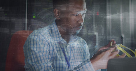 Image of data processing over african american male worker in server room. Global business and digital interface concept digitally generated image.の写真素材