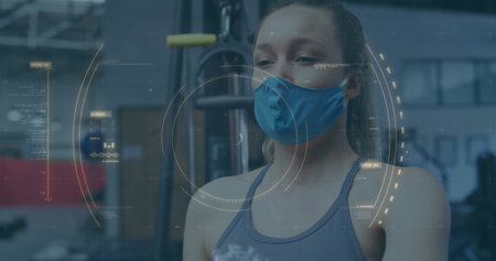 Image of covid-19 cell spinning over caucasian woman wearing face mask sneezing. Global covid 19pandemic concept digitally generated image.の写真素材