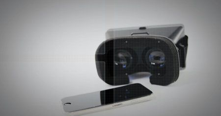A smartphone and VR headset on a white background. These devices represent modern technology's...
