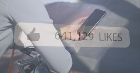 Businesswoman checks her smartphone outdoors, with copy space. Her social media post has garnered a...
