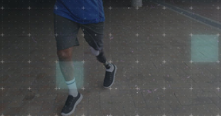 Biracial man with a prosthetic leg walks outdoors. His resilience shines as he navigates the sidewalk confidently.の写真素材