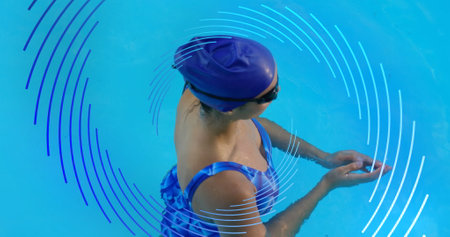 Image of blue line spiral rotating over woman swimming in pool. sport and fitness concept, digitally...
