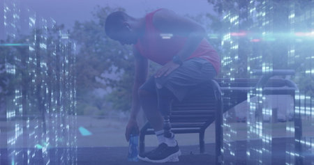 Image of computer servers processing data over male athlete with prosthetic leg resting outdoors....