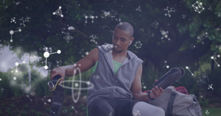 Image of communication networks over disabled male athlete attaching running blade outdoors. sport,...