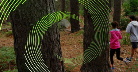 Image of green line spiral rotating over woman and man running in forest. sport and fitness concept,...