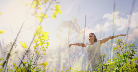 Woman enjoys breeze in grassland.