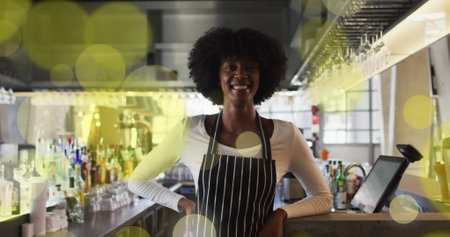 Image of spots over african american female worker in shop. Global business and digital interface concept digitally generated image.の写真素材