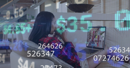 Image of numbers changing and financial data processing over woman using laptop on image call....