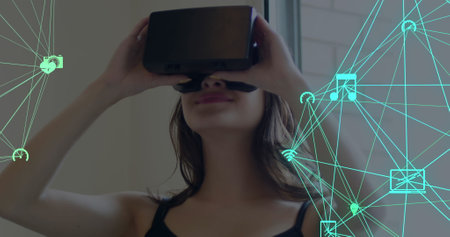 Image of digital interface with globes with network of connections over woman using VR headset....