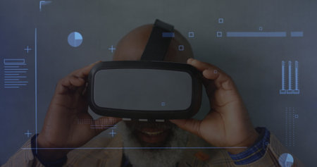 Digital interface with data processing against african american senior man removing vr headset....