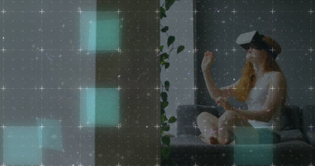Light trails moving over grid network against caucasian woman wearing vr headset at home. computer...