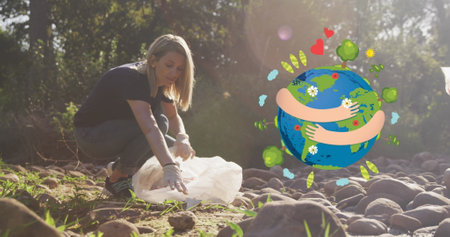 Image of hugging globe over happy caucasian woman picking up rubbish in countryside. eco conservation volunteer month digitally image.の写真素材