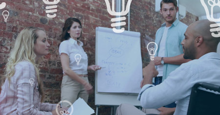 Image of light bulb over disabled diverse woman and man sitting in wheelchair. International day of persons with disabilities concept digitally generated image.の写真素材