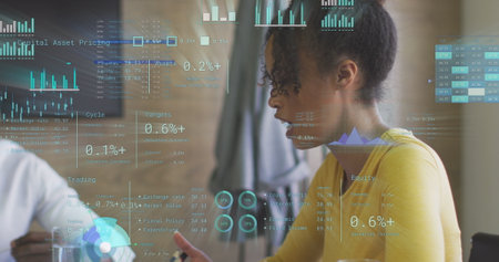 Image of statistics and data processing over biracial businesswoman in office. Global business, finances, computing and data processing concept digitally generated image.の写真素材