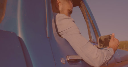 Biracial man getting in his car and adjusting the side view mirror. Travel and road trip conceptの写真素材
