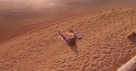 Aerial view of a woman with her dog sunbathing at the beach. Travel, vacation and leisure conceptの写真素材