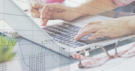 Image of financial data processing over schoolchild working in an office, using laptop computer....