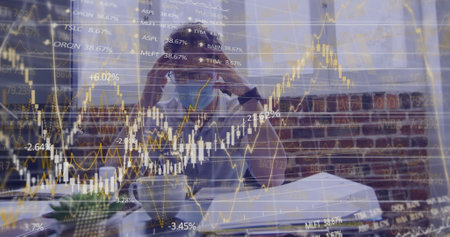 Image of financial data processing over businessman wearing face mask. global business, finances,...