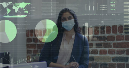 Image of financial data processing over businesswoman wearing face mask. global business, finances, connections and digital interface during covid 19 pandemic concept digitally generated image.の写真素材