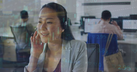 Image of financial data and graphs over asian woman in office. Business, finance, economy, cooperation and communication concept digitally generated image.の写真素材