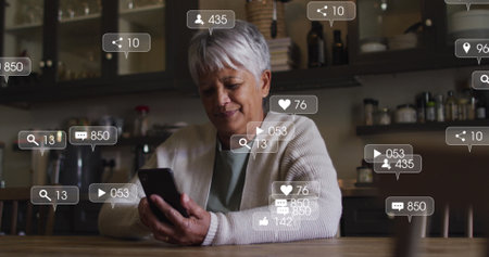 Image of social media icons and numbers on banners over senior woman using smartphone. global...