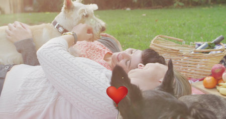 Image of red heart balloon icons over female couple with pet dog. National love your pet day concept digitally generated image.の写真素材