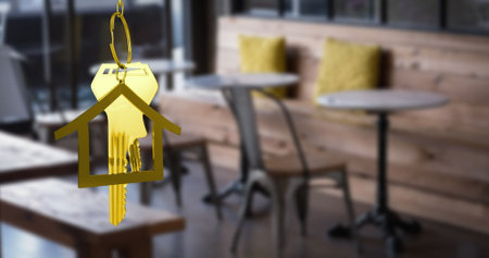 Image of hanging golden house keys against interior of a cafe. Interior designing and real estate conceptの写真素材