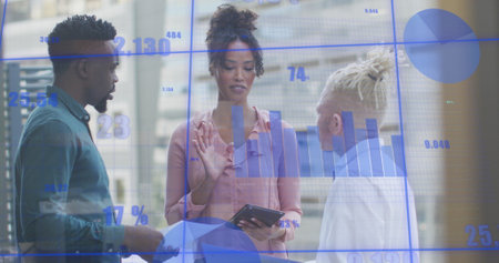Image of graphs with changing numbers, diverse coworkers discussing reports on laptop. Digital...
