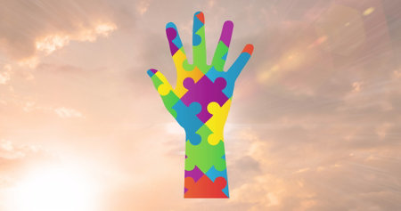 Colorful puzzle pieces forming hand shape are rising against a bright sky. Sunlight casting a warm glow around vibrant colors, creating a striking visualの写真素材