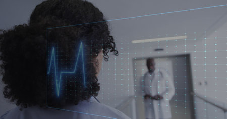 Biracial woman with curly hair looking at African American doctor. Both discussing health in...