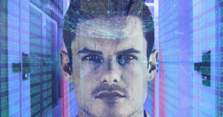 Caucasian male with short brown hair standing in data center. Wearing a dark shirt, looking directly...