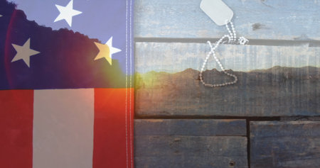 American flag and dog tags resting on rustic wooden surface, symbolizing patriotism. Sunlight gently...