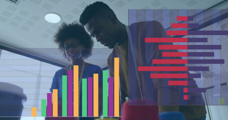 African American male and biracial female professionals are examining financial data. Both are...