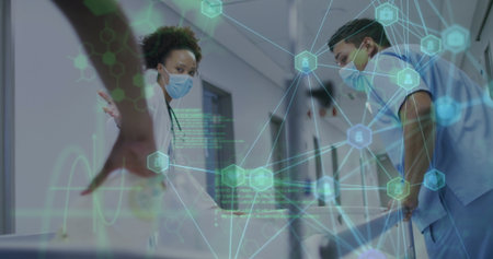 Biracial nurse and Hispanic doctor examining digital data in hospital. Both wearing scrubs, focusing...
