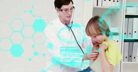 Caucasian mother wearing glasses, examining her son with stethoscope. She has short brown hair; he, blonde, donning a yellow shirtの写真素材