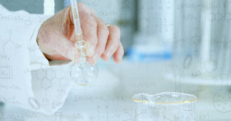 Caucasian senior male scientist holding flask, examining a clear liquid. Surrounded by chemical...