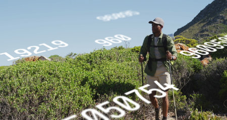 Biracial male trainer wearing hat, hiking in mountainous terrain. He has short black hair, light brown skin, and dressed in outdoor gear, exploring natureの写真素材