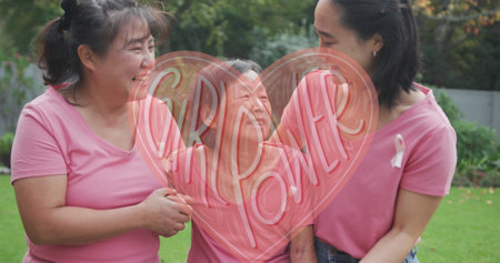 Asian female fitness instructor and participants laughing in park. Wearing pink t-shirts, enjoying a sunny day outdoorsの写真素材