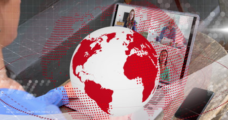Image of red and white globe rotating over woman making laptop image call with for colleagues. Global communication , working remotely and digital interface concept digitally generated image.の写真素材