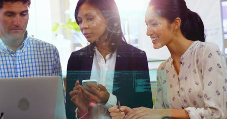 Image of screens of data processing over diverse colleagues discussing over a laptop at office. Computer interface and business technology conceptの写真素材