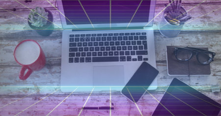 Image of squares moving over desk with technology devices in office. Global business and digital...