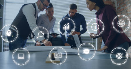 Image of digital icons against diverse colleagues discussing together over a plan at office. Global...