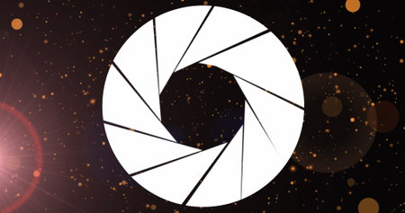 Image of lens diaphragm icon over orange spots and spots of light against black background. Technology conceptの写真素材