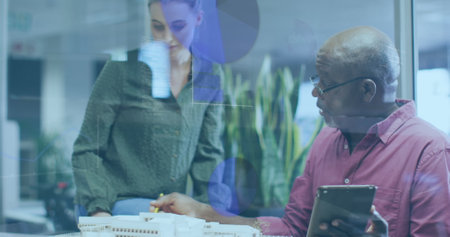 Image of multiple graphs and computer language, diverse coworkers discussing on desk. Digital...