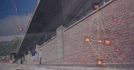 Image of connected icons globe over african american man running beside brick wall. Digital...