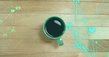 Image of connected icons globes over overhead view of coffee cup on wooden table. Digital composite, multiple exposure, communication, globalization, beverage and technology concept.の写真素材