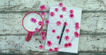 A close-up of a coffee cup, notepad, and pen on a wooden plank, with an image of a network of...
